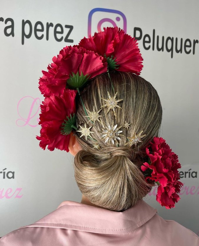 Recogido bajo de flamenca con flores rojas y peinecillos dorados, visto de espaldas